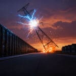 Rows of data center server racks on the left, a collapsing high-voltage transmission tower throwing sparks in the center, and a row of darkened powerless houses on the right at dusk